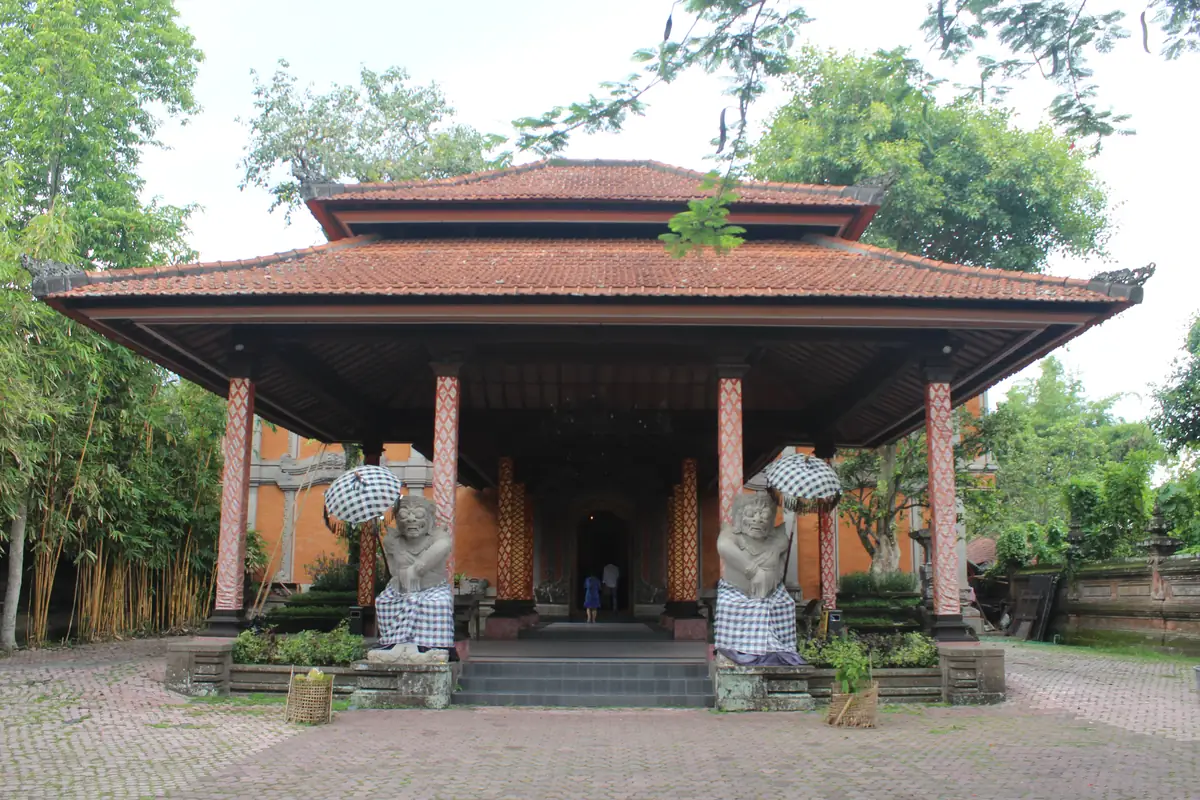 Red-tiled entrance pavilion with guardian statues at the Agung Rai Museum of Art in Ubud.